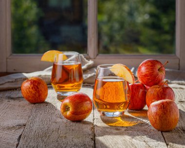 Bir bardak elma suyu ve dilimlenmiş elmalar.