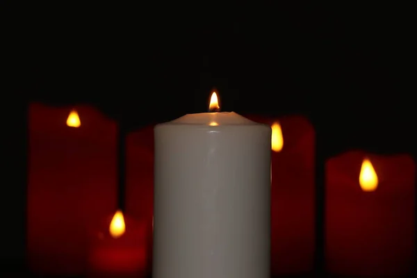 Red electronic candles and white candles isolated on a black background