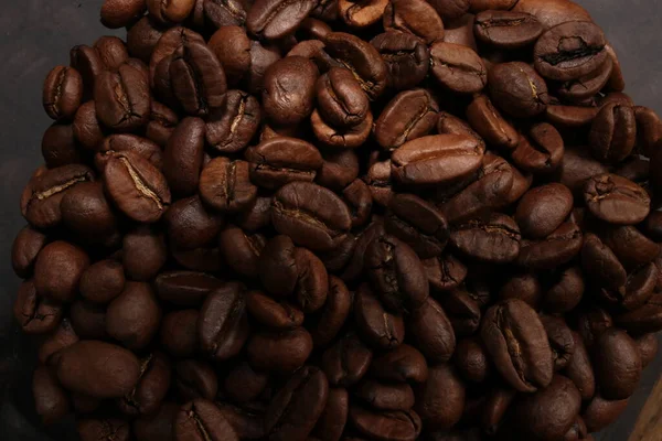 Büyük miktarlarda koyu kahve çekirdekleri, yakın plan, siyah arka planda izole edilmiş.