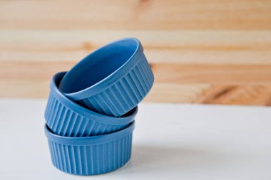 Tabaklar ve tabaklar mavi arka planda bayram masası servis etmek için. Seramik çanak takımı ve mavi havlu.