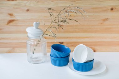 Tabaklar ve tabaklar mavi arka planda bir festival masasına servis yapmak için..