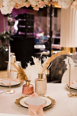 Lüks bir düğünde masa hazırlamak ve masada güzel çiçekler. Düğün dekoru, çiçekler, pembe ve altın dekoru, mumlar. Kutlama tablosu dekoru.