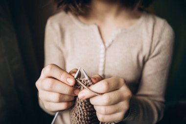 Çocukların elinde örgü iğneleri var. Yakın plan. Hobi kavramı, yaratıcılık, nakış, el işi..