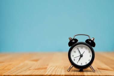 Mavi arkaplanda siyah alarm saati, yumuşak odak, seçici odak