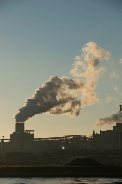 Puesta de sol en fábrica de acero mostrando chimeneas de humo — Foto de Stock