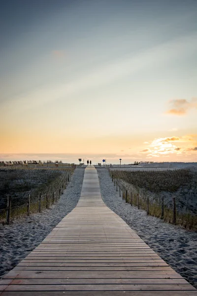 Trä gångväg till stranden i solnedgången — Stockfoto