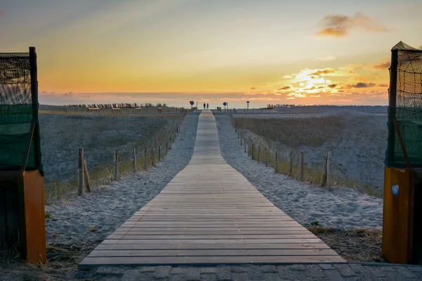 Trä gångväg till stranden i solnedgången — Stockfoto