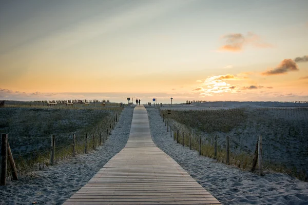 Trä gångväg till stranden i solnedgången — Stockfoto
