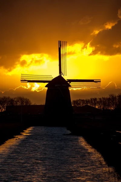 Hinterleuchtete holländische Windmühle bei Sonnenaufgang — Stockfoto