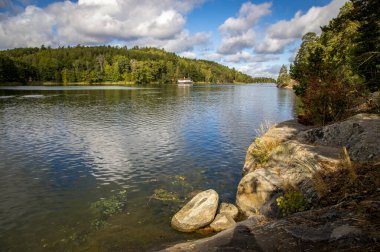 Bir yaz gününde bulutlu bir gökyüzünün altında bir göl