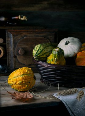 Kırsal bir masada hasır bir sepetin içinde balkabakları