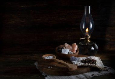 Eski lamba, ahşap bir masada tuz ve biber.