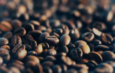 Ahşap bir masada kavrulmuş büyük kahve çekirdekleri.