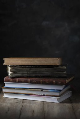 Tahta masadaki kitap yığını.