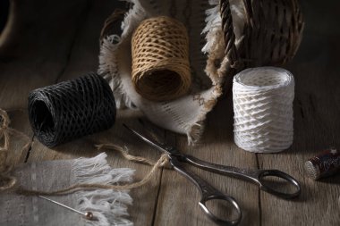 Eski bir makas, iplik ve kırsal bir masada bir sepet.