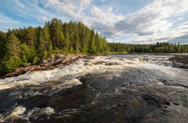 Blue spring sky over forest and fast river
