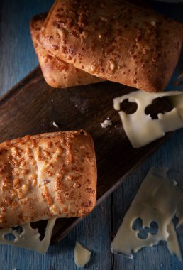 Cheese buns and sliced cheese on a blue rustic table