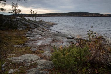 Bulutlu bir sonbahar gününde Rocky Gölü kıyısı