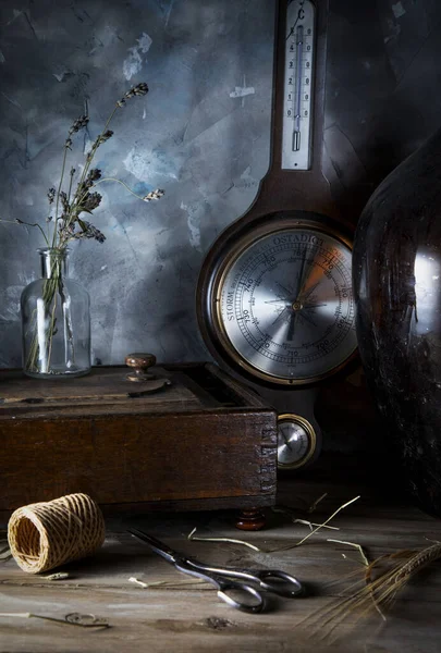 Vintage jewelry box and old barometer on a wooden table. Weather modes are written on the dial in Swedish