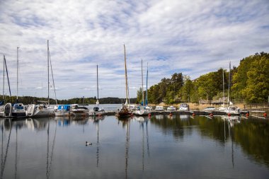 Gustavsberg 'de. Göl üzerinde mavi bulutlu gökyüzü, tekneler ve yatlar