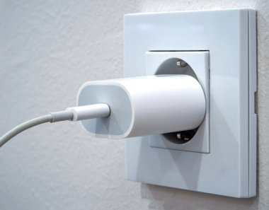 Bir prize takılı bir cep telefonu şarj cihazını kapat