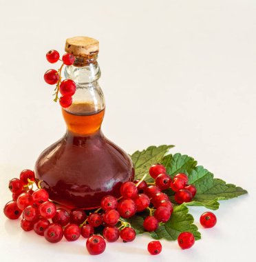 Yaprağın üzerinde üzümlü brendi şişesinin yanında frenk üzümü.