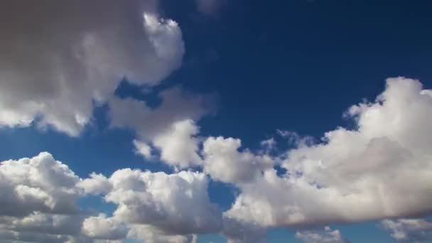 Timelapse de nubes cruzando el cielo azul sobre la tierra — Vídeos de Stock