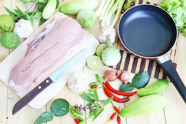 Ahşap zemin üzerine kurulu, boş pan ve taze sebze doğrama üzerinde domuz eti.