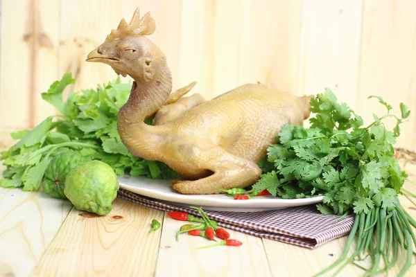Chicken and vegetables on wooden background