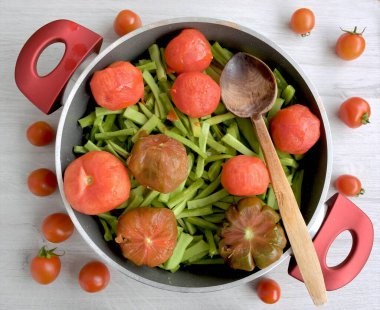 Bir tencerede pişirilmesi için doğranmış sebze, domates ve yeşil fasulye.