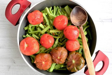Bir tencerede pişirilmesi için doğranmış sebze, domates ve yeşil fasulye.