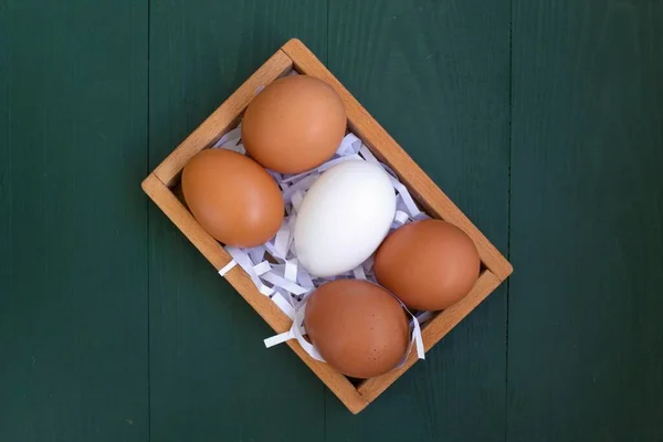 yellow and white eggs in a wooden box