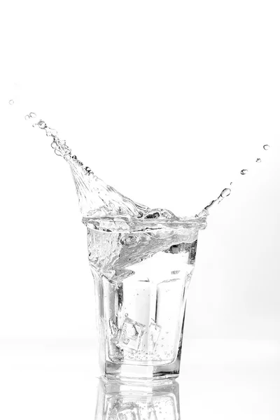 Eiswürfel spritzen in Wasserglas — Stockfoto