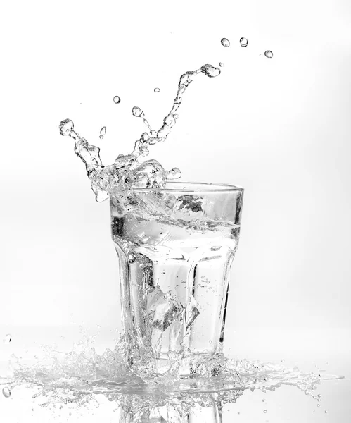 Eiswürfel spritzen in Wasserglas — Stockfoto