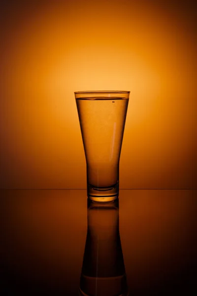 Vaso de agua sobre fondo naranja —  Fotos de Stock