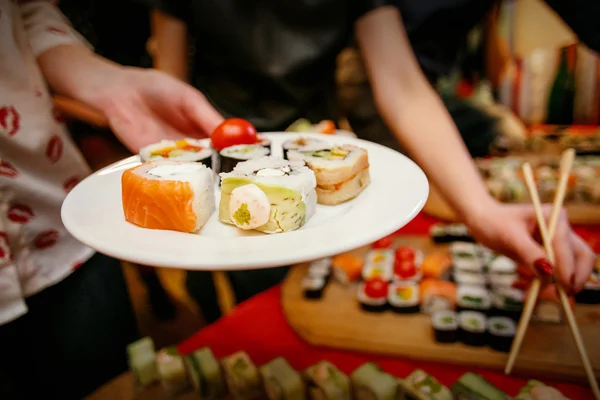 Sushi lunch, handen met stokjes — Stockfoto