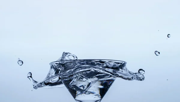 Лід у склянці з бризкою води — стокове фото