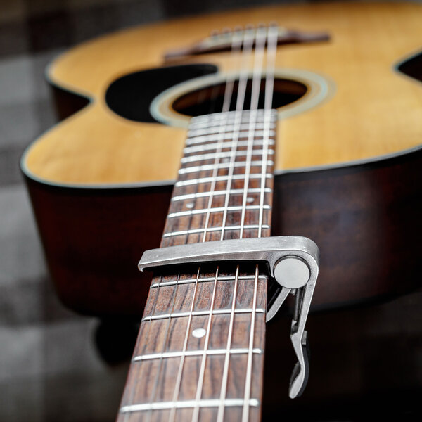 Acoustic guitar neck with a capo