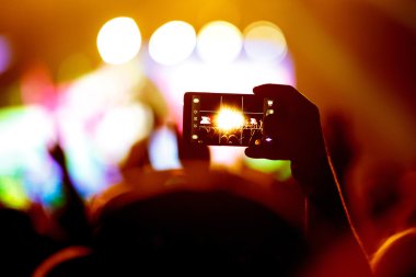 Canlı müzik festivali akıllı telefon kayıtlarıyla konser sahnesinin fotoğrafını çekiyor.