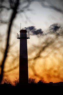 Gün batımında bacadan duman çıkıyor.