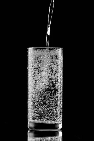 Gießen Von Wasser Ein Glas Auf Schwarzem Hintergrund — Stockfoto