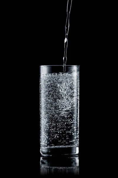 Gießen Von Wasser Ein Glas Auf Schwarzem Hintergrund — Stockfoto