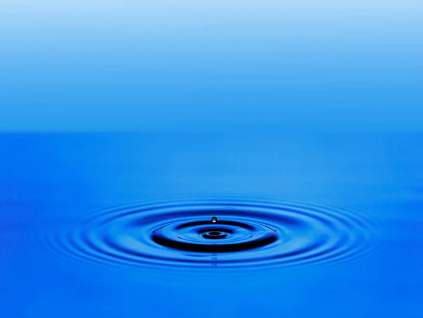A ondulação círculo da superfície da água azul. — Fotografia de Stock