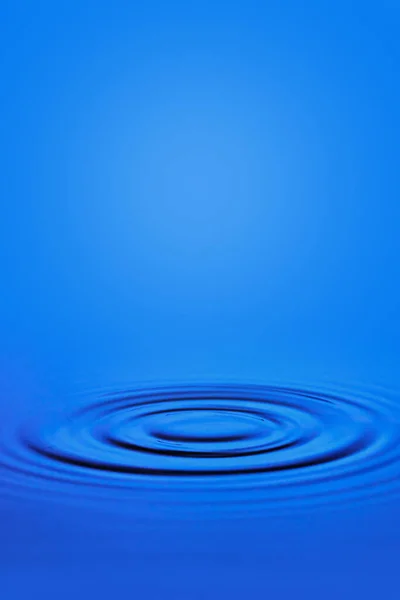 Circular waves on the surface of the blue water. — Stock Photo, Image