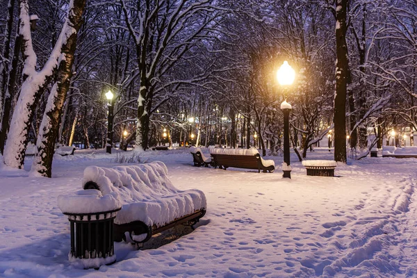 街の公園で雪に覆われたベンチ 冬景色 — ストック写真