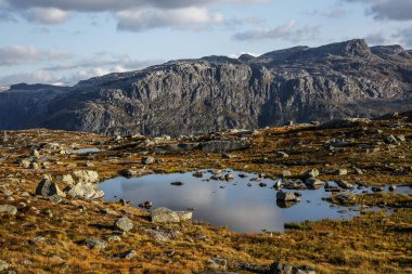 Gün batımında küçük gölleri olan dağ manzaraları vadisi. Norveç 'te trolltunga' ya giden yol