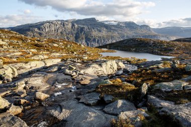 Gün batımında küçük gölleri olan dağ manzaraları vadisi. Norveç 'te trolltunga' ya giden yol