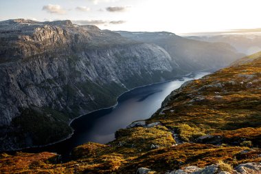 Norveç dağlarında gün batımı. Fiyorttaki turuncu ışık.