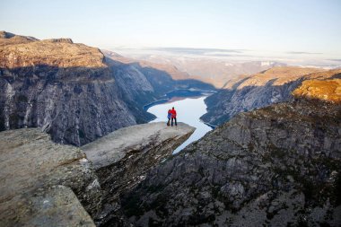 Trolltunga. Norveç - 04.09.19: Norveç 'te trolltunga' da mutlu bir aile. Erkek ve kız kucaklaşır