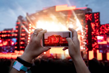Açık hava konserinde fotoğraf ve video çekmek için cep telefonu kamerası kullanmak..